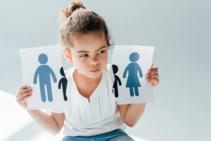A child holding a ripped piece of paper showing her parents getting a divorce