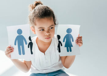 A child holding a ripped piece of paper showing her parents getting a divorce